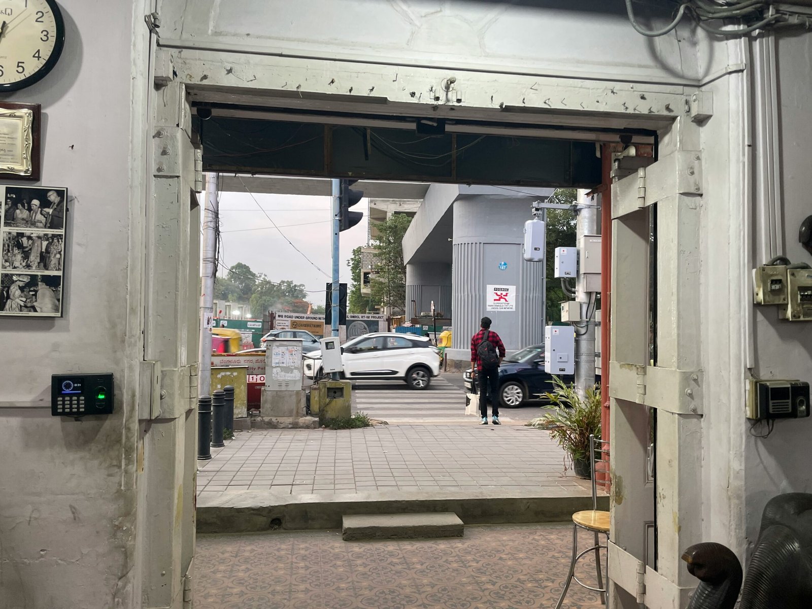 a man walking into a building with a clock on the wall