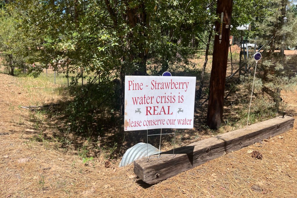 Outside a home in Arizona’s Pine-Strawberry community, a sign urges others to conserve water and that the water crisis in the district is real. Credit: Wyatt Myskow/Inside Climate News