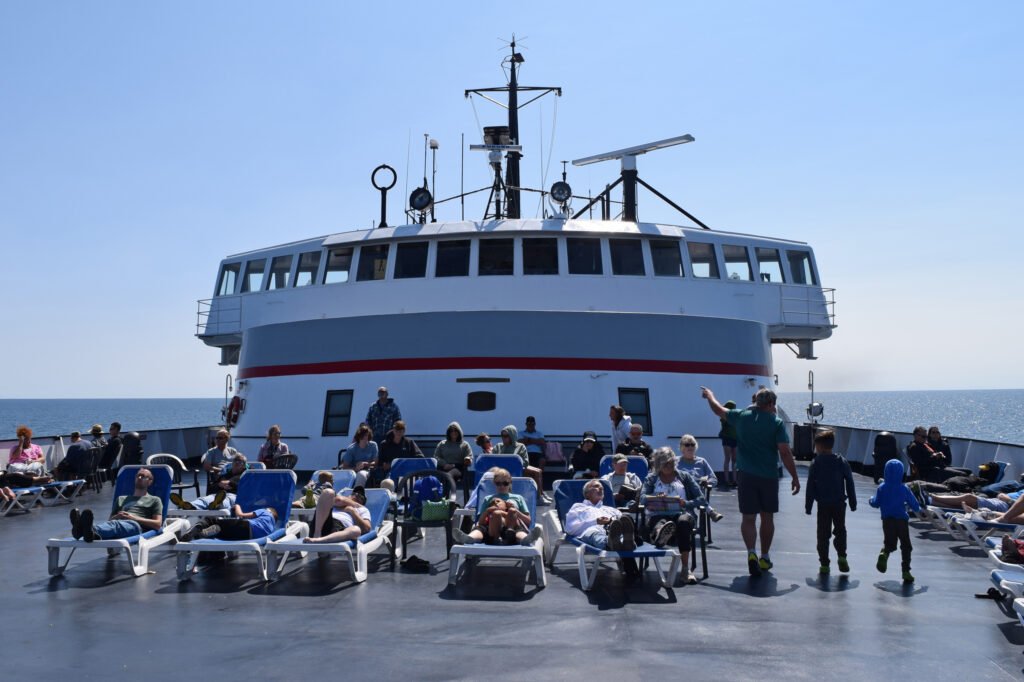 Travelers relax on the top deck of the S.S. Badger as it crosses Lake Michigan from Ludington, Mich. to Manitowoc, Wis. Credit: Phil McKenna/Inside Climate News