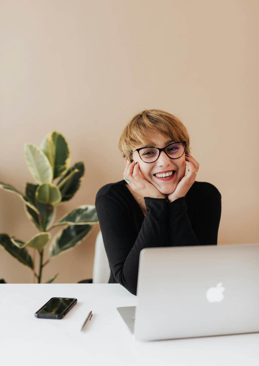 beautiful employee sitting at desk with laptop